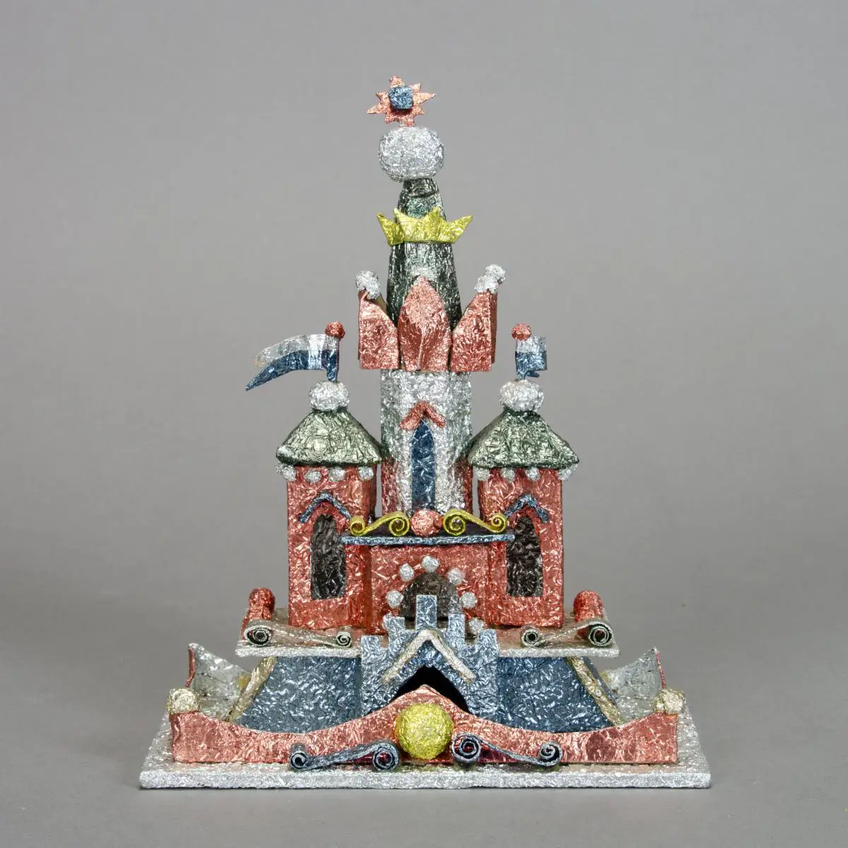 Metallic paper covering posterboard sculpture of a building with domed towers, spires, and crimped metallic tin details.
