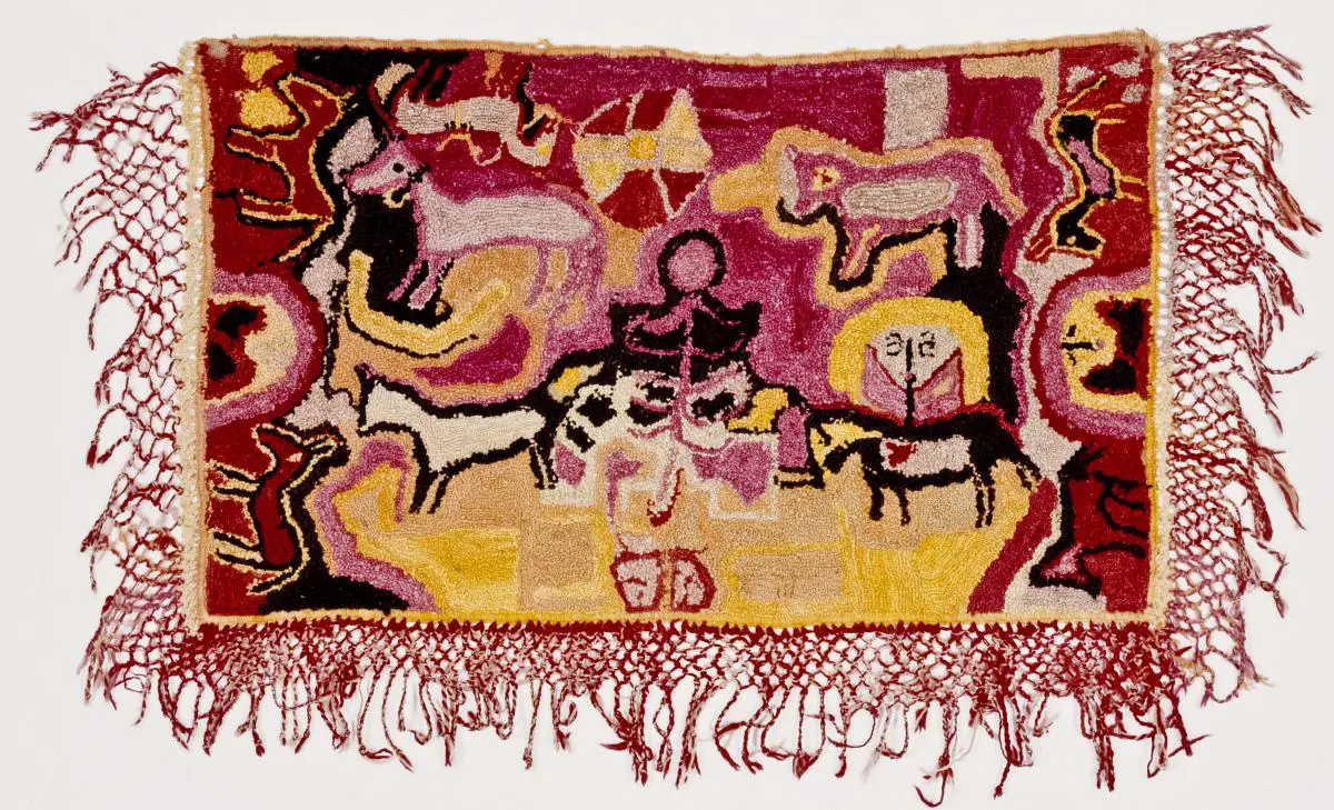 Wall hanging with animals and a figure in shades of pink, red, and yellow, bordered by netted red fringe.