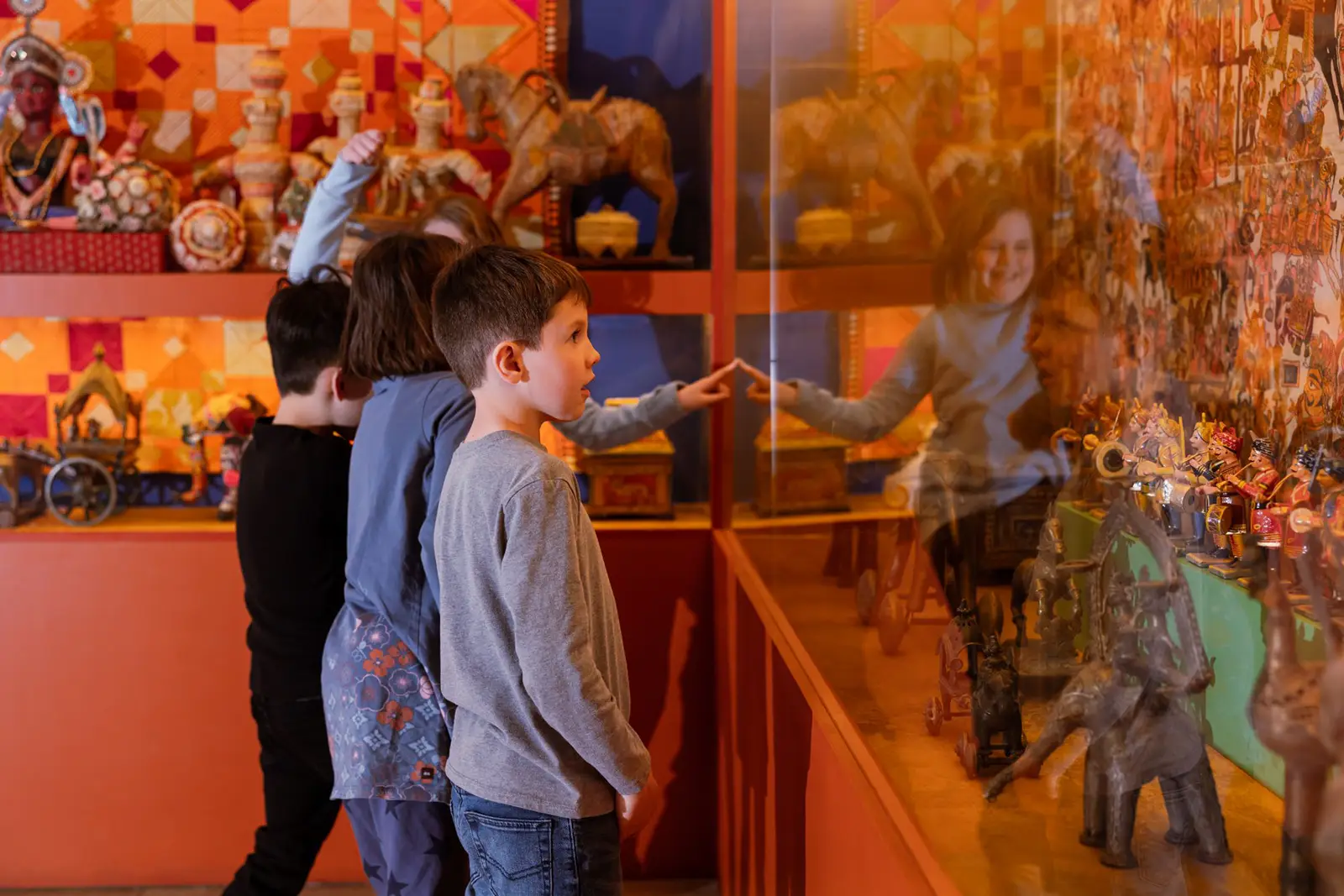 large-exhibition-at-Multple-Visions-Common-Bond Group of kids looking in and pointing to figures playing instruments in the Multple Visions: A Common Bond exhibition