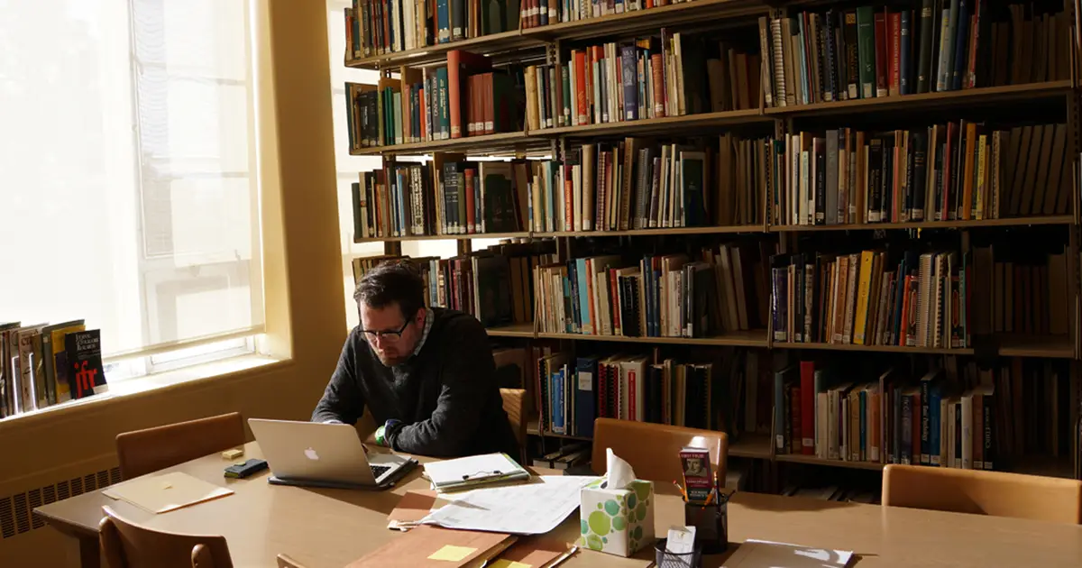 library-in-use Man working on a laptop in a library